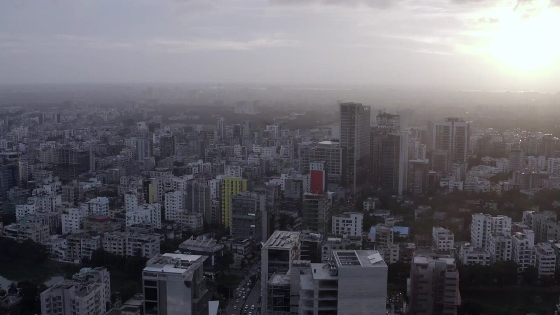 Aerial view of Gulshan, Dhaka at sunset with high-rise buildings emerging from haze
