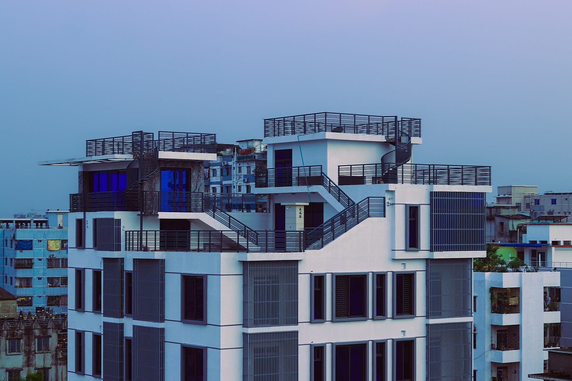 Modern residential building in Mugda with terraced rooftops at blue hour